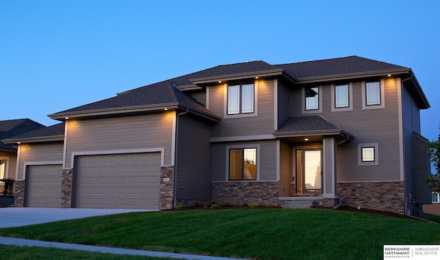 prairie-style house with a garage and a lawn