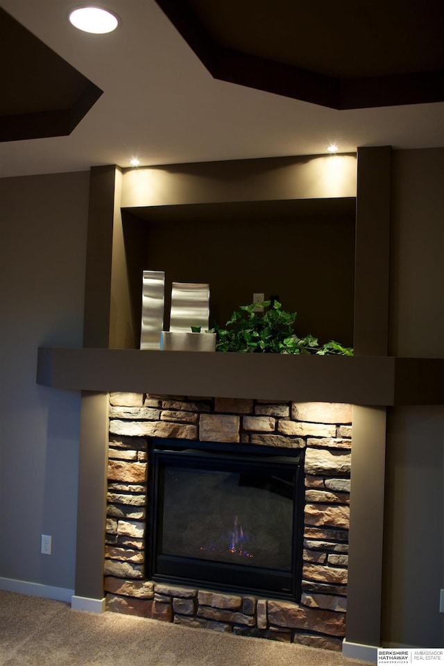 details with carpet floors and a stone fireplace