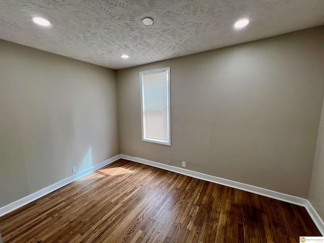 spare room with a textured ceiling and hardwood / wood-style floors