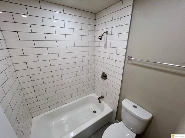 bathroom featuring toilet and tiled shower / bath