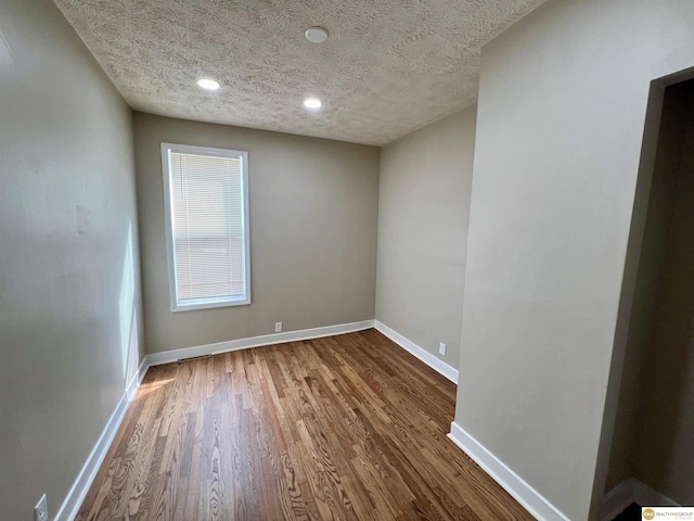 spare room featuring a textured ceiling and hardwood / wood-style floors