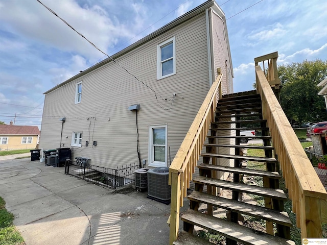 rear view of house with central air condition unit and a patio