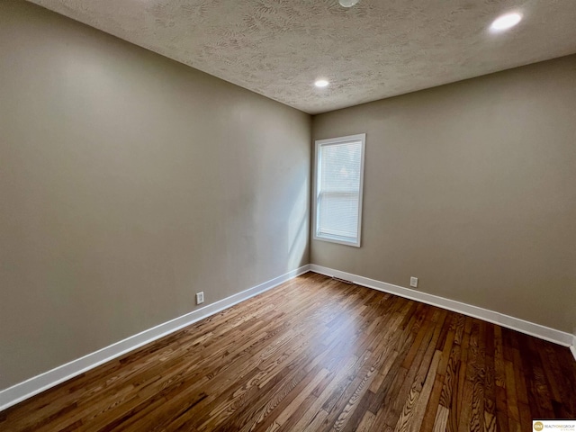 spare room with wood-type flooring and a textured ceiling