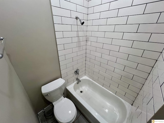 bathroom with tiled shower / bath combo and toilet