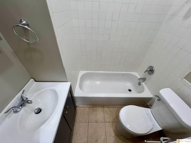 full bathroom featuring tile patterned flooring, vanity, tiled shower / bath, and toilet