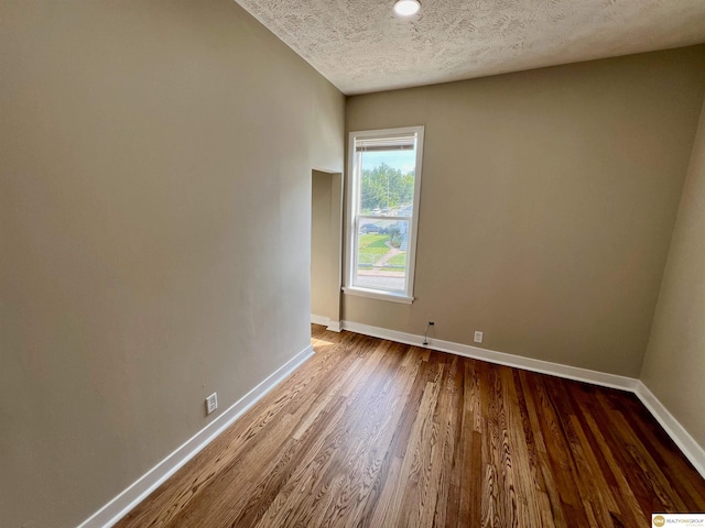 spare room with a textured ceiling and hardwood / wood-style floors