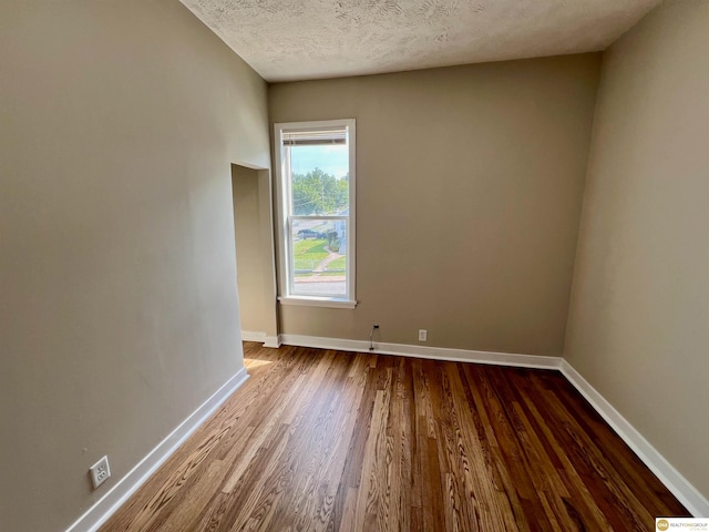 unfurnished room with a textured ceiling and hardwood / wood-style floors