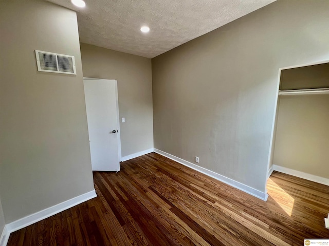 unfurnished bedroom featuring dark wood-type flooring and a textured ceiling