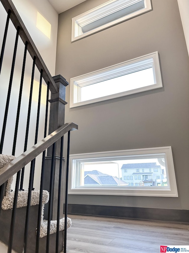 stairway featuring plenty of natural light and wood finished floors