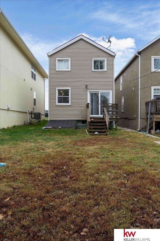 back of property with central air condition unit and a lawn