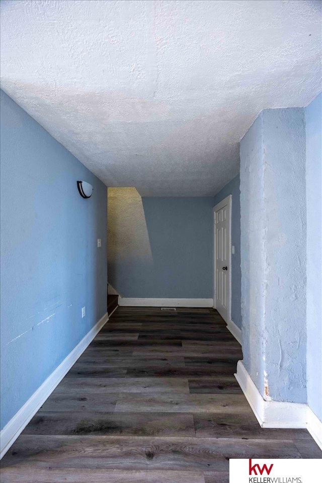 hall featuring dark hardwood / wood-style floors and a textured ceiling