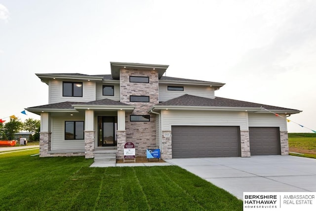 prairie-style home featuring a front lawn and a garage