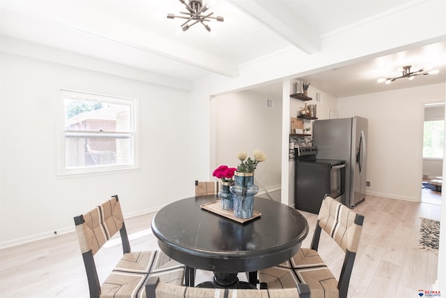 dining room with light wood-type flooring, beamed ceiling, a healthy amount of sunlight, and an inviting chandelier