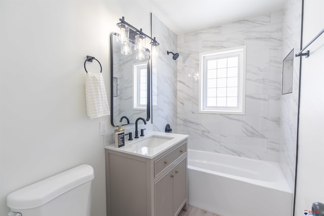 full bathroom with tiled shower / bath, vanity, and toilet