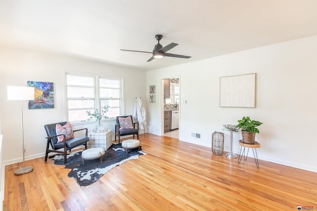 sitting room featuring light wood-type flooring and ceiling fan