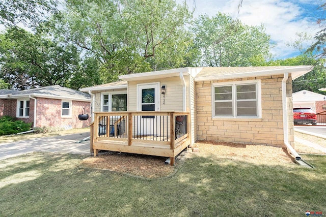 exterior space with a wooden deck, a lawn, and a garage