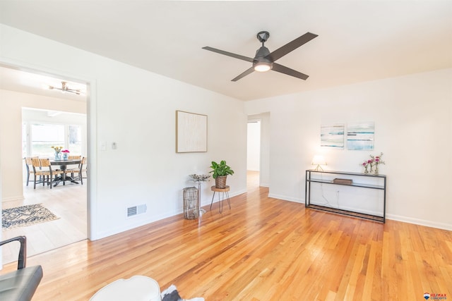 living room with light wood-type flooring and ceiling fan