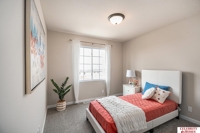 bedroom featuring a textured ceiling and dark carpet