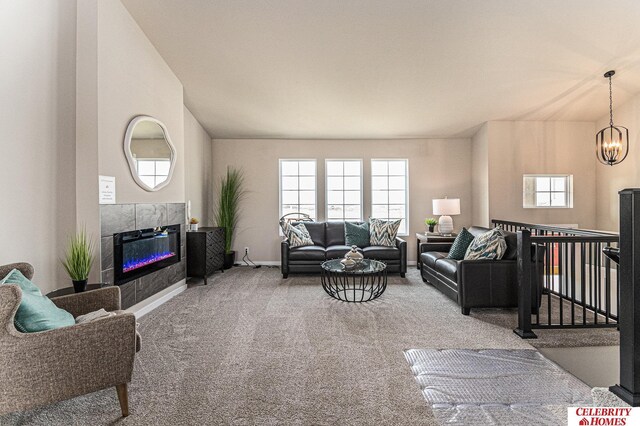 living room featuring carpet, a tiled fireplace, and a chandelier