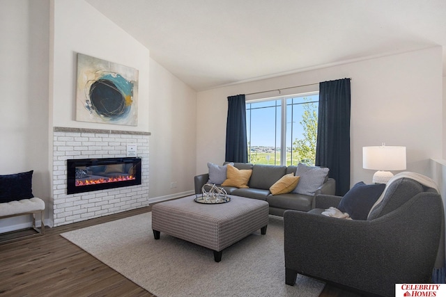 living room featuring lofted ceiling, hardwood / wood-style floors, and a brick fireplace