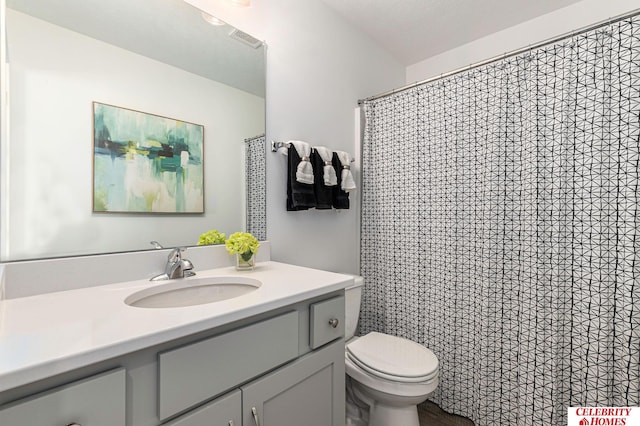 bathroom with vanity, toilet, and curtained shower