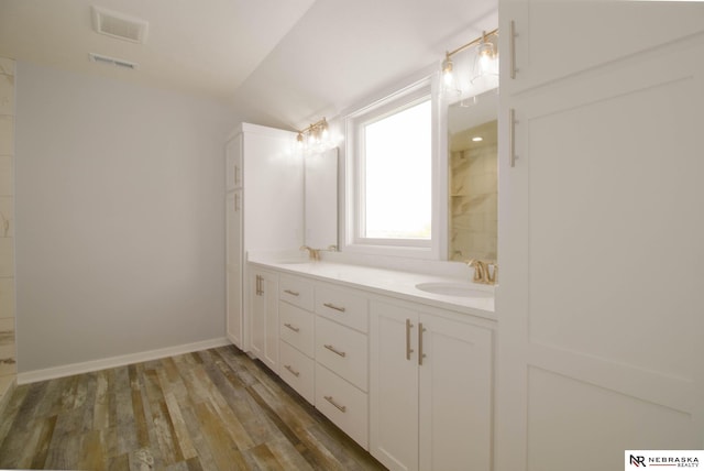 bathroom featuring vaulted ceiling, hardwood / wood-style floors, and vanity