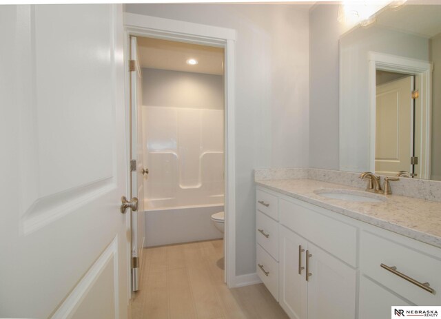 full bathroom with vanity, shower with separate bathtub, toilet, and hardwood / wood-style flooring