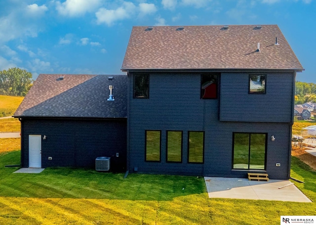 rear view of house with cooling unit, a yard, and a patio