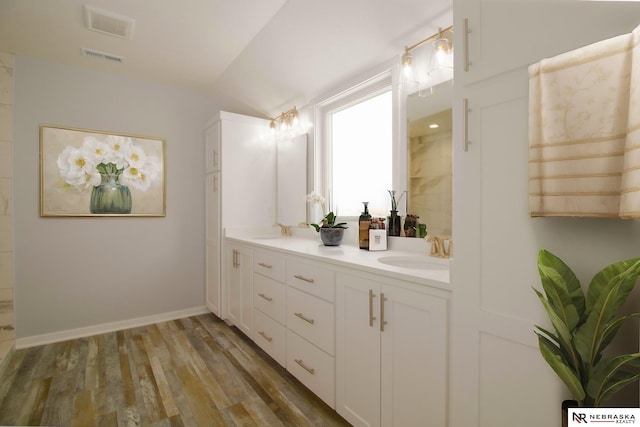 bathroom with vaulted ceiling, hardwood / wood-style flooring, and vanity