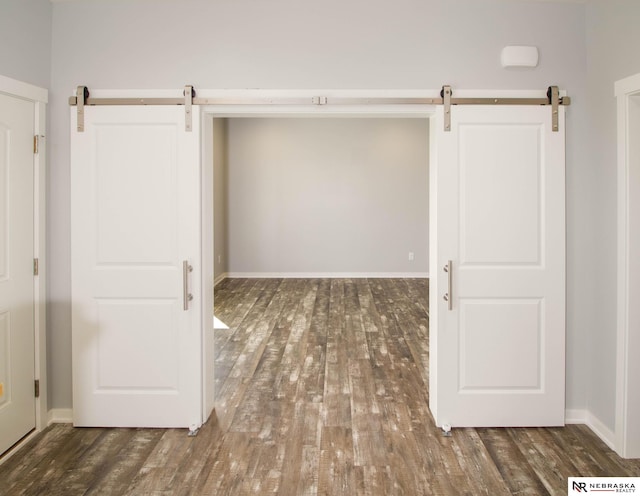 interior space with dark wood-type flooring and a barn door