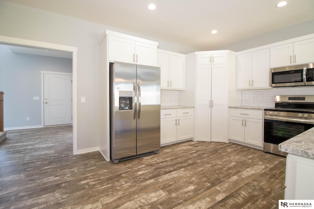 kitchen with white cabinetry, appliances with stainless steel finishes, and dark hardwood / wood-style flooring