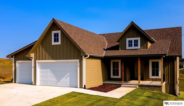 view of front of home featuring a front lawn, a garage, and covered porch