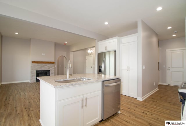 kitchen featuring appliances with stainless steel finishes, sink, an island with sink, and white cabinets