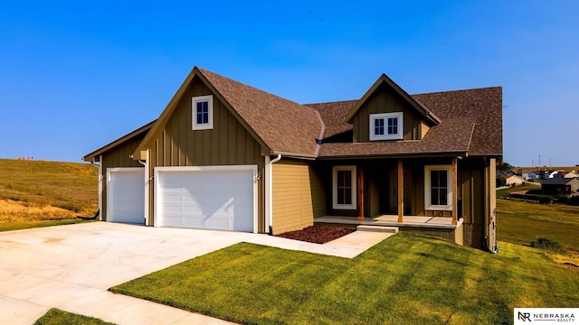 view of front of property featuring a garage, a front lawn, and covered porch