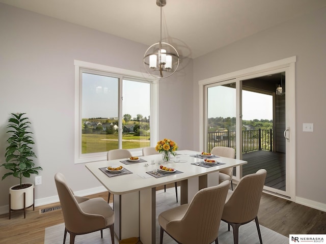 dining area with hardwood / wood-style floors and a chandelier