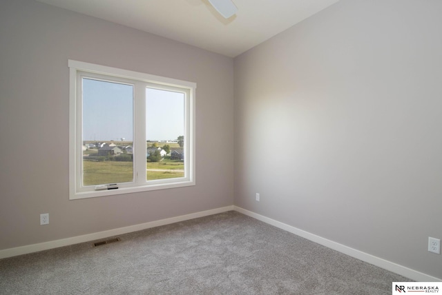 spare room featuring light carpet and ceiling fan