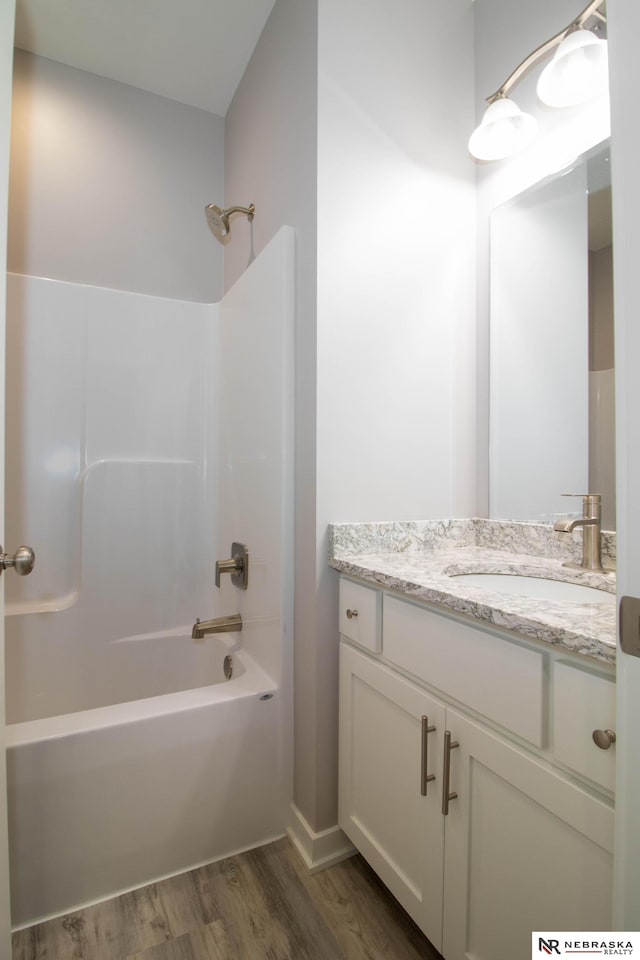 bathroom with shower / tub combination, vanity, and wood-type flooring