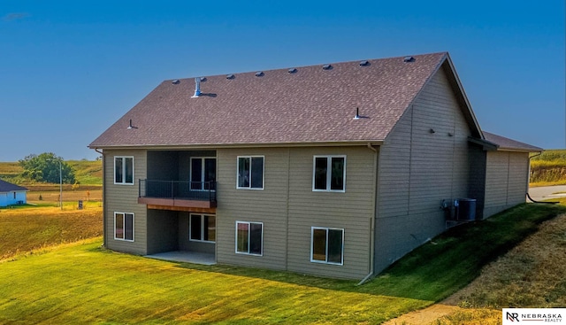 rear view of house featuring a yard, a balcony, and a patio area