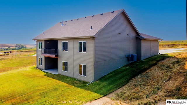 view of side of property with a balcony and a yard