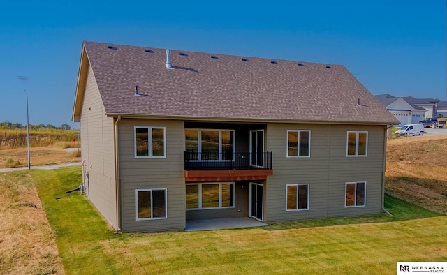 rear view of house with a balcony, a yard, and a patio area