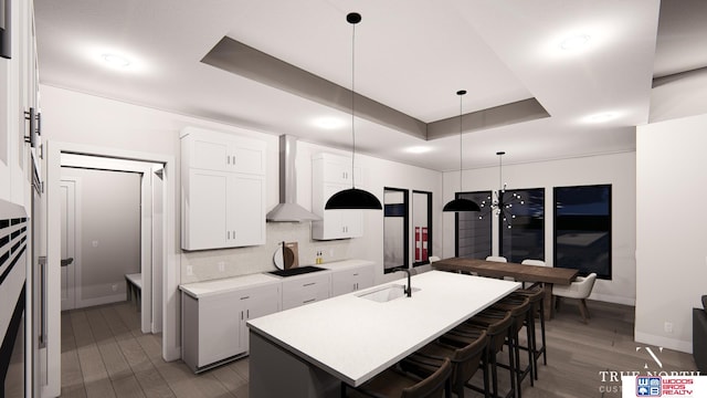 kitchen featuring white cabinetry, dark hardwood / wood-style flooring, sink, a center island with sink, and wall chimney range hood