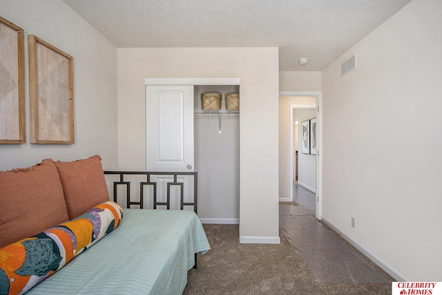 bedroom with a textured ceiling, a closet, and carpet floors