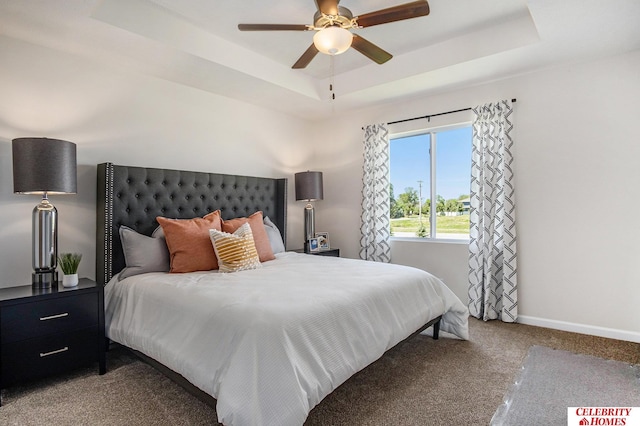 bedroom with a raised ceiling, ceiling fan, and carpet floors