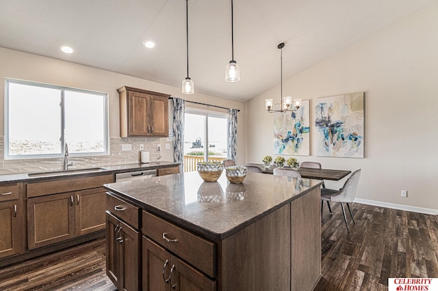 kitchen with decorative light fixtures, a kitchen island, dark hardwood / wood-style flooring, and sink