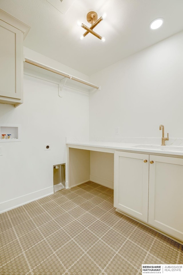 washroom featuring hookup for an electric dryer, washer hookup, a sink, baseboards, and cabinet space