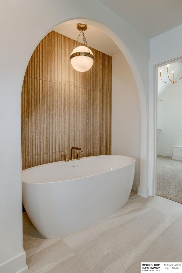 bathroom featuring a soaking tub and baseboards