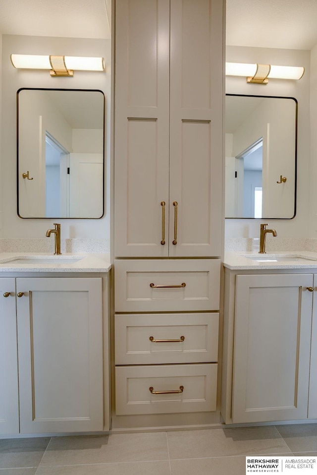 bathroom with tile patterned floors, two vanities, and a sink