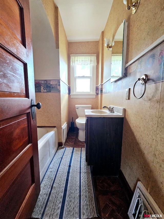 bathroom featuring a tub, toilet, and vanity