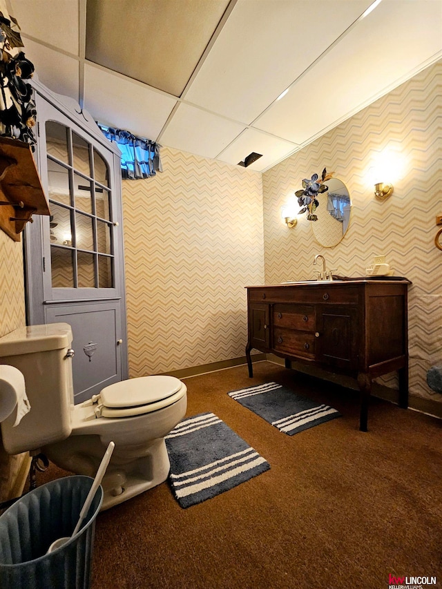 bathroom featuring a paneled ceiling, toilet, and vanity