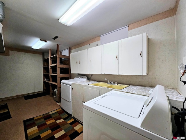 clothes washing area with sink, cabinets, and separate washer and dryer